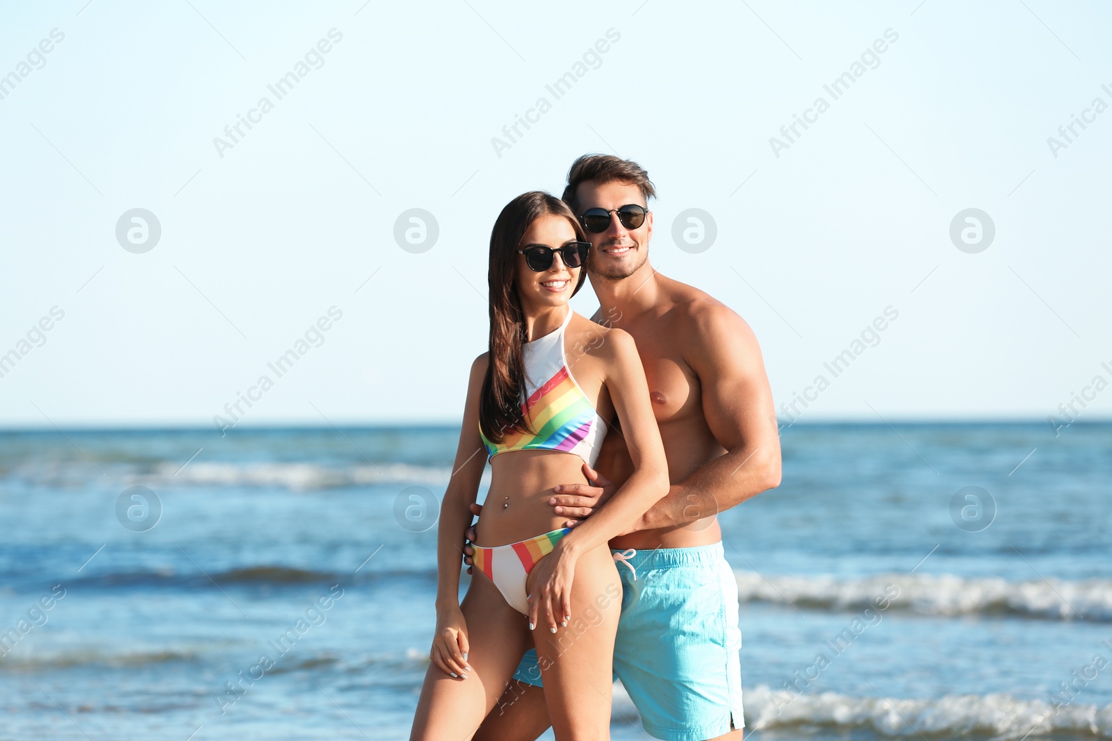 Photo of Happy young couple posing near sea on beach