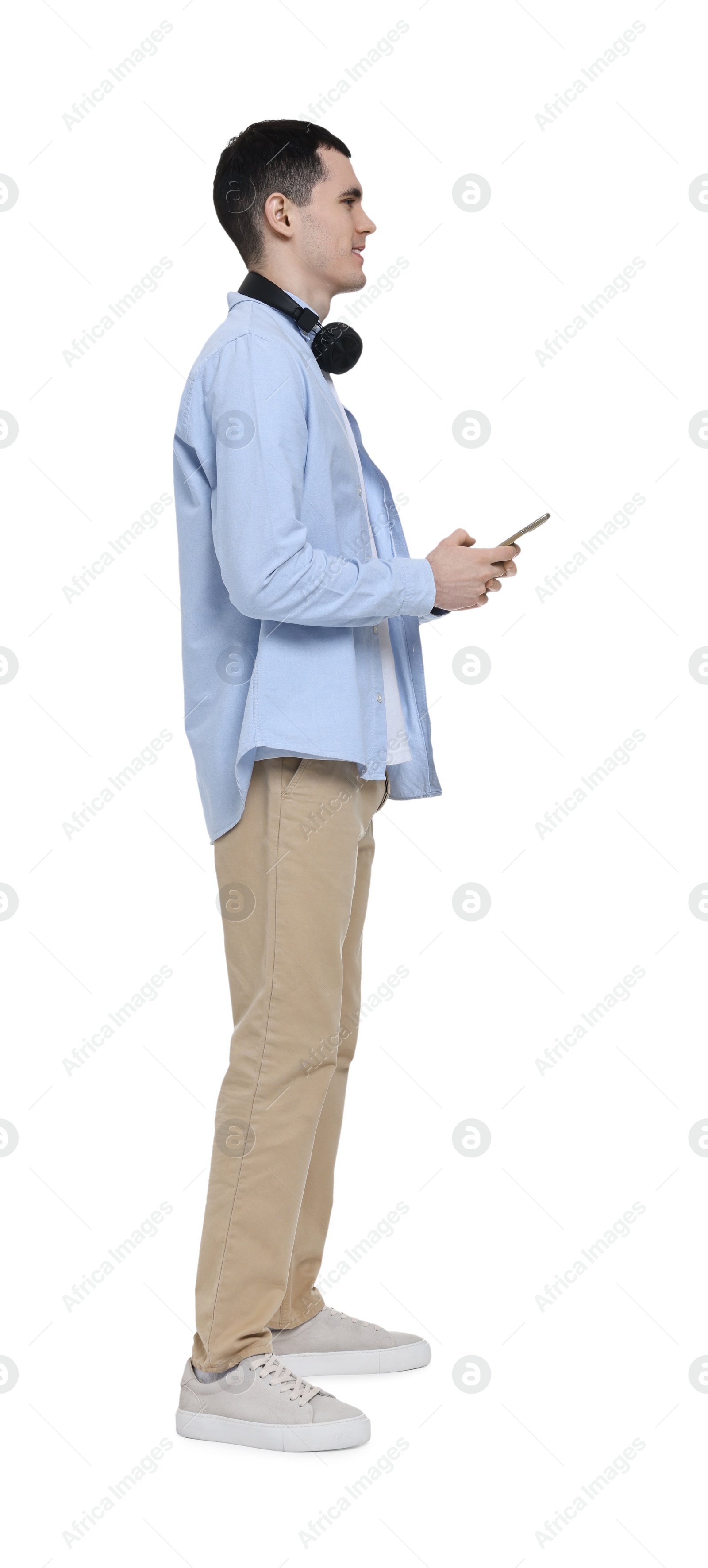 Photo of Young man with headphones using mobile phone on white background