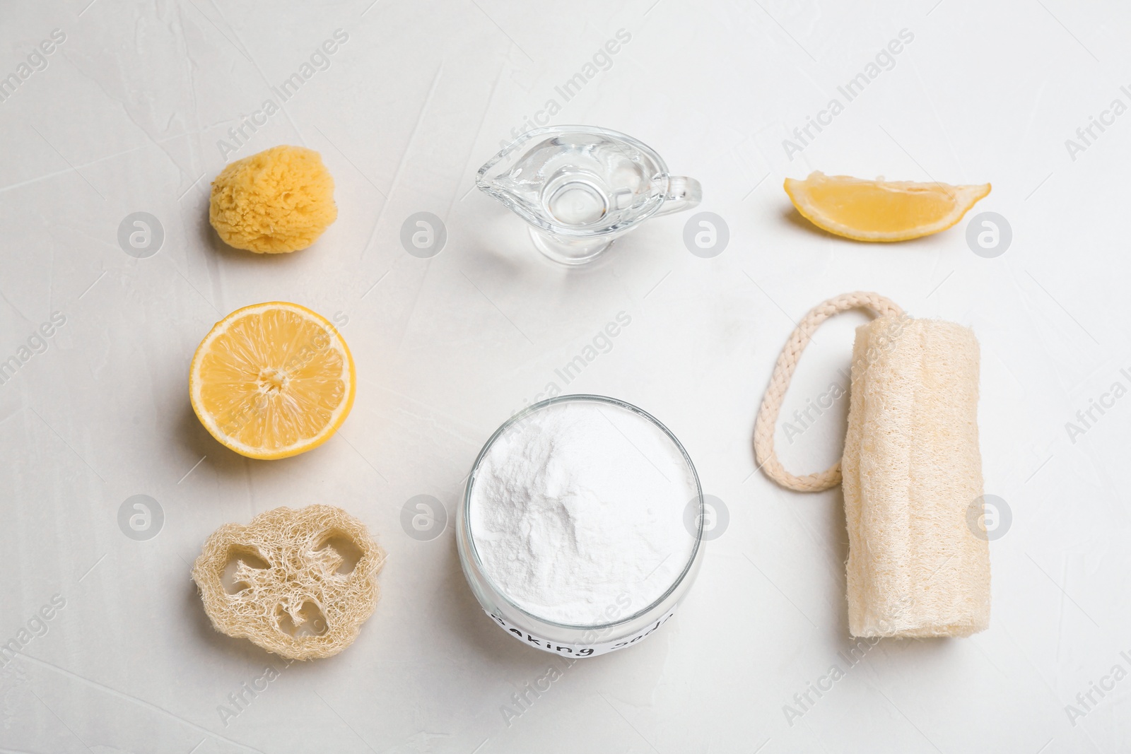 Photo of Flat lay composition with bowl of baking soda, lemon and cleaning items on gray table