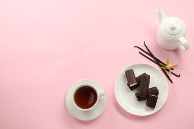 Glazed curd cheese bars, vanilla pods and tea on pink background, flat lay. Space for text