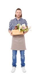 Male florist holding basket with flowers on white background