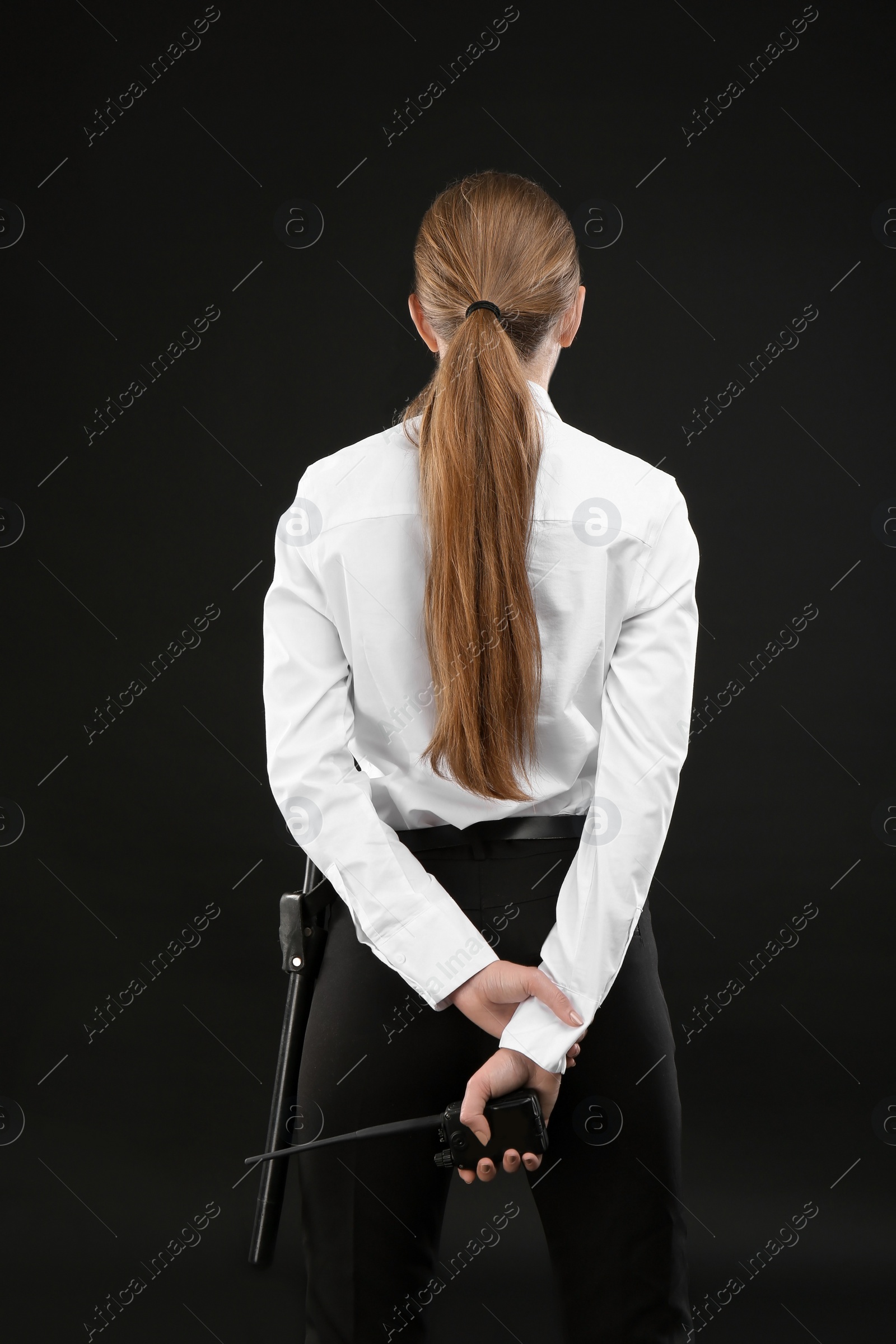 Photo of Female security guard with portable radio transmitter on dark background