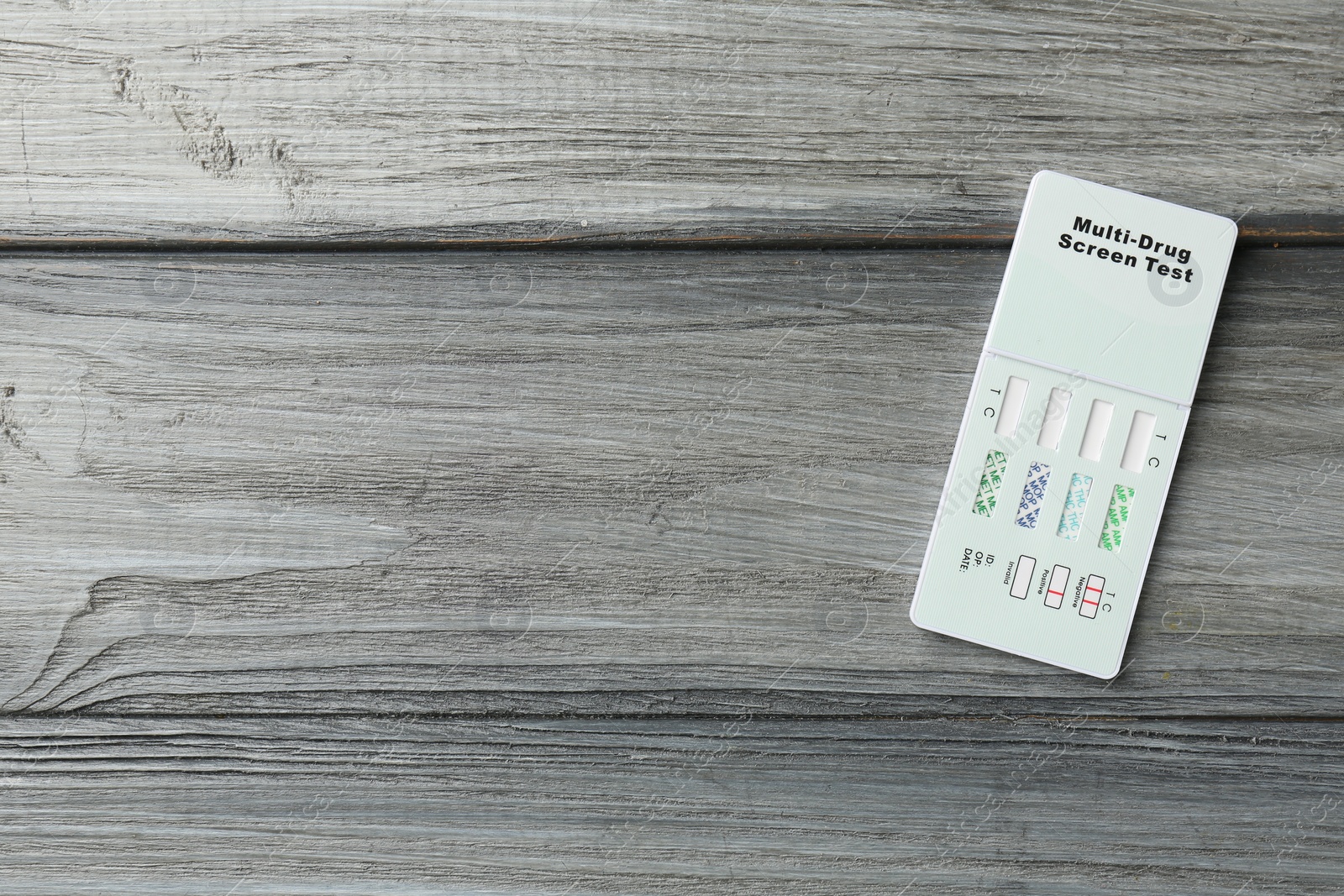 Photo of Multi-drug screen test on grey wooden table, top view. Space for text