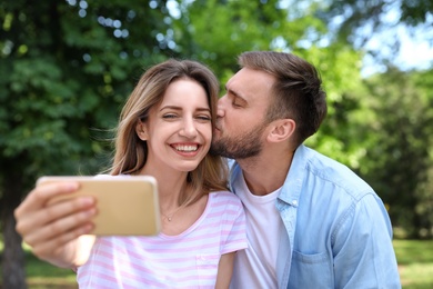 Photo of Happy young couple taking selfie in park