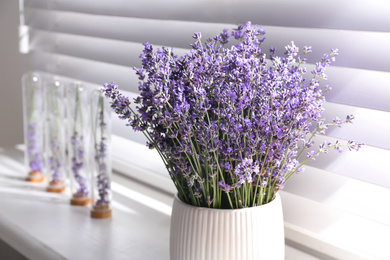 Beautiful lavender flowers on window sill indoors, closeup