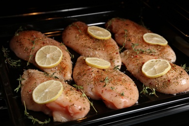 Chicken breasts with lemon and rosemary on baking sheet