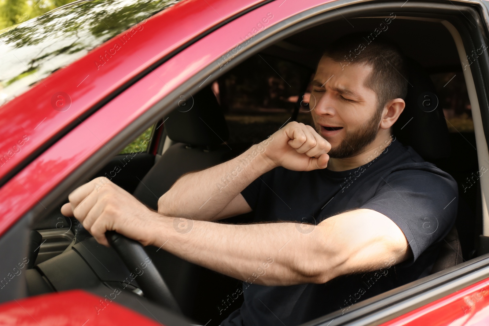 Photo of Tired man yawning while driving his modern car