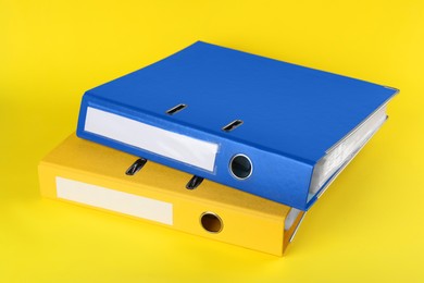 Photo of Bright hardcover office folders on yellow background