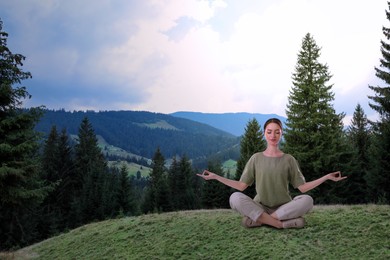 Image of Woman meditating in mountains, space for text