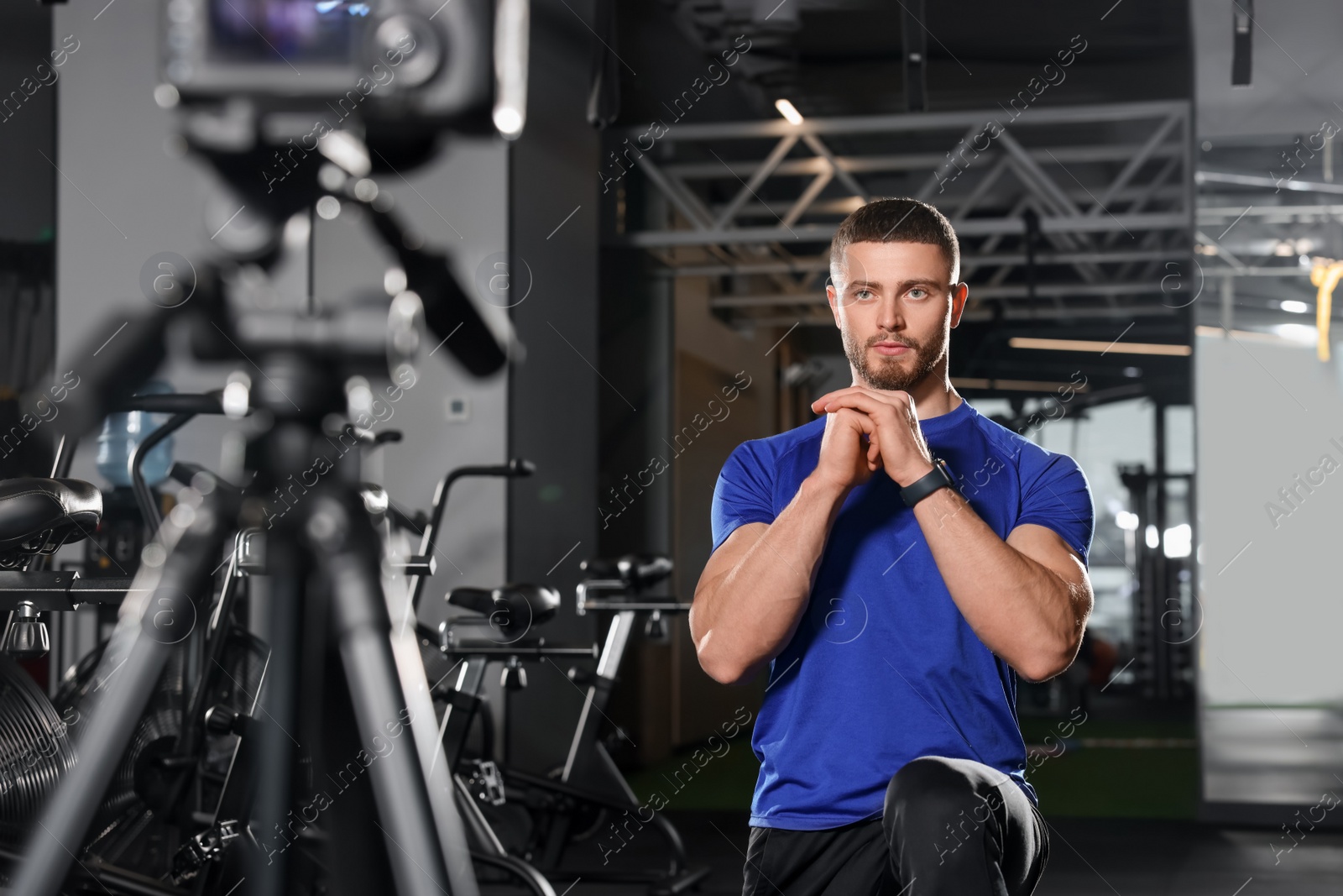 Photo of Man recording workout on camera at gym. Online fitness trainer