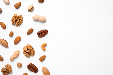 Different delicious nuts on white background, flat lay. Space for text