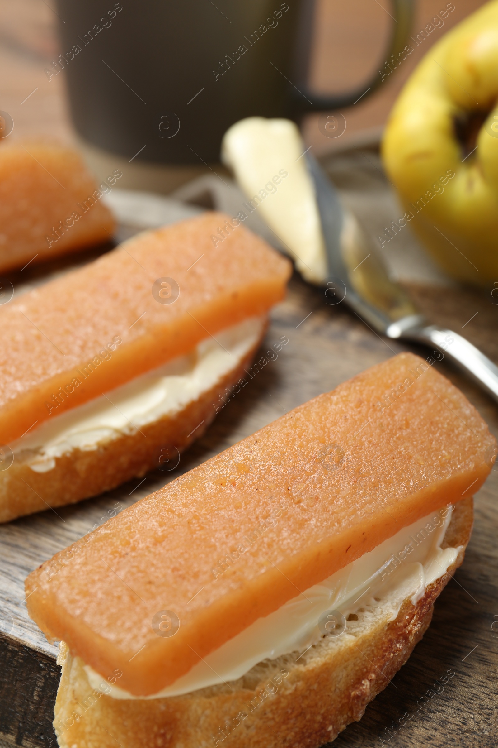 Photo of Quince paste sandwiches and fresh fruit on table, closeup