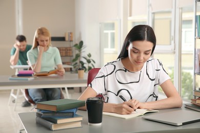 Young woman studying at table in library
