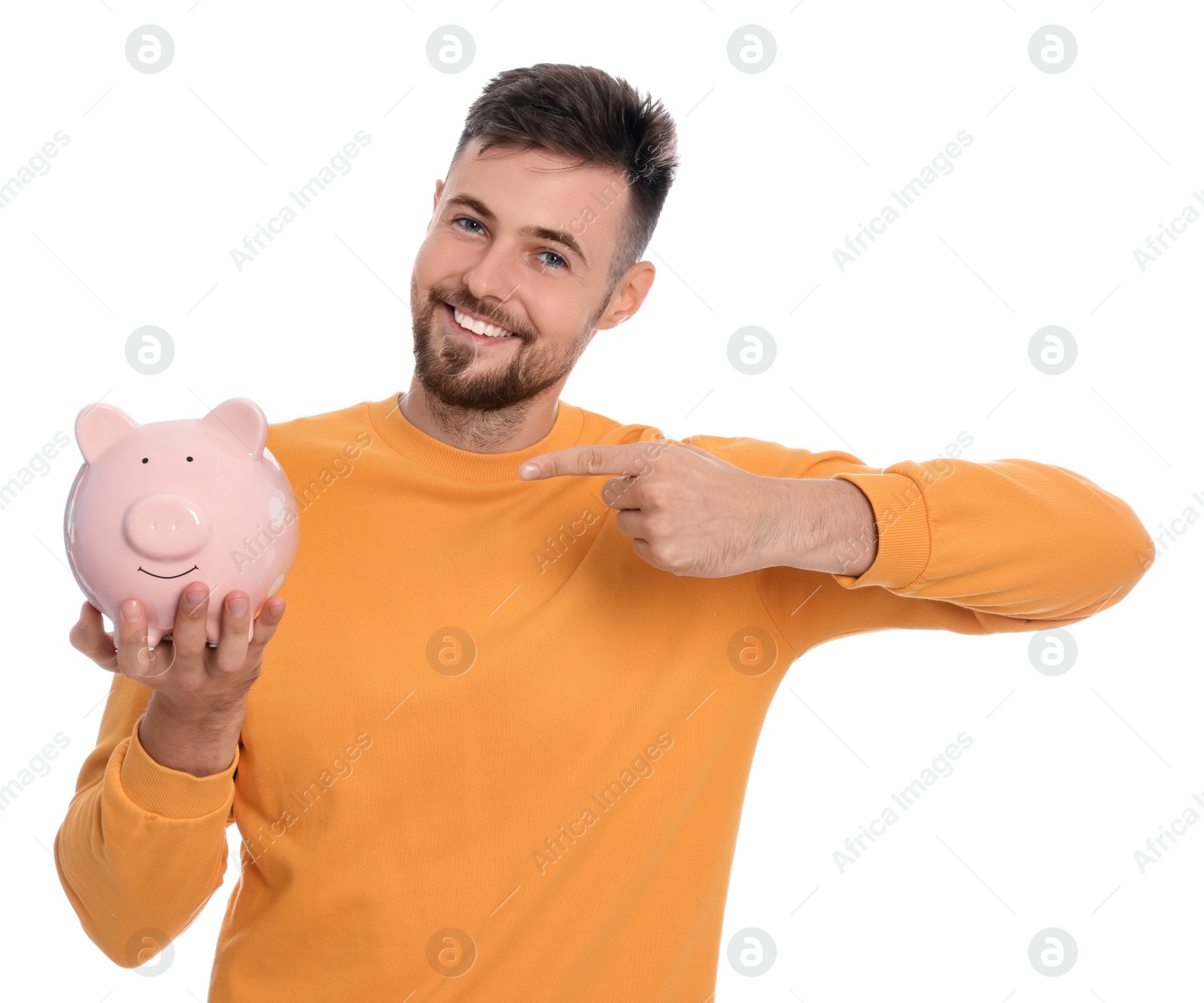 Photo of Happy young man with piggy bank on white background