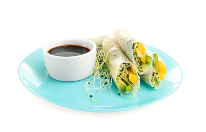 Photo of Delicious rolls wrapped in rice paper and soy sauce on white background