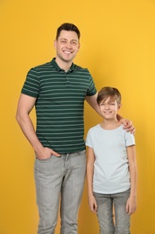 Photo of Portrait of dad and his son on color background