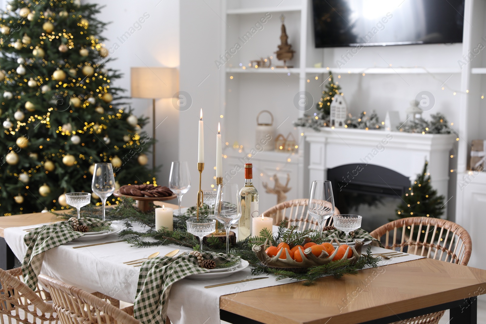 Photo of Christmas table setting with festive decor and dishware in living room