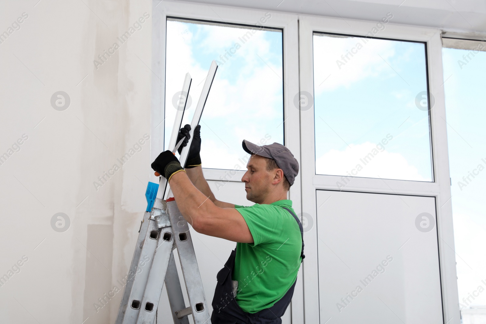 Photo of Worker with materials for window installation indoors