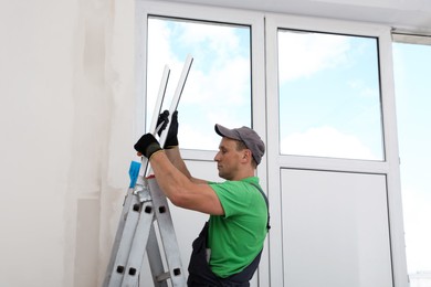 Photo of Worker with materials for window installation indoors