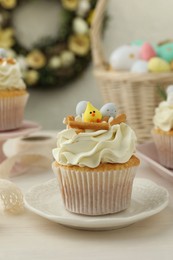 Photo of Tasty Easter cupcakes with vanilla cream on light wooden table