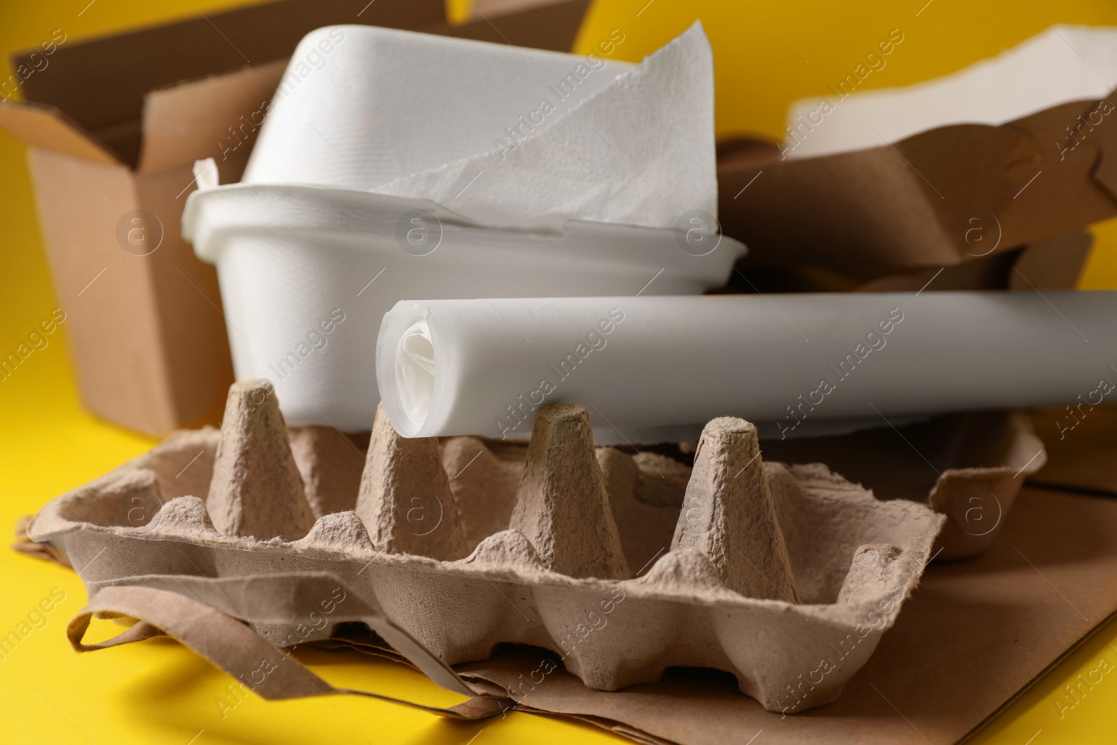 Photo of Heap of waste paper on yellow background, closeup