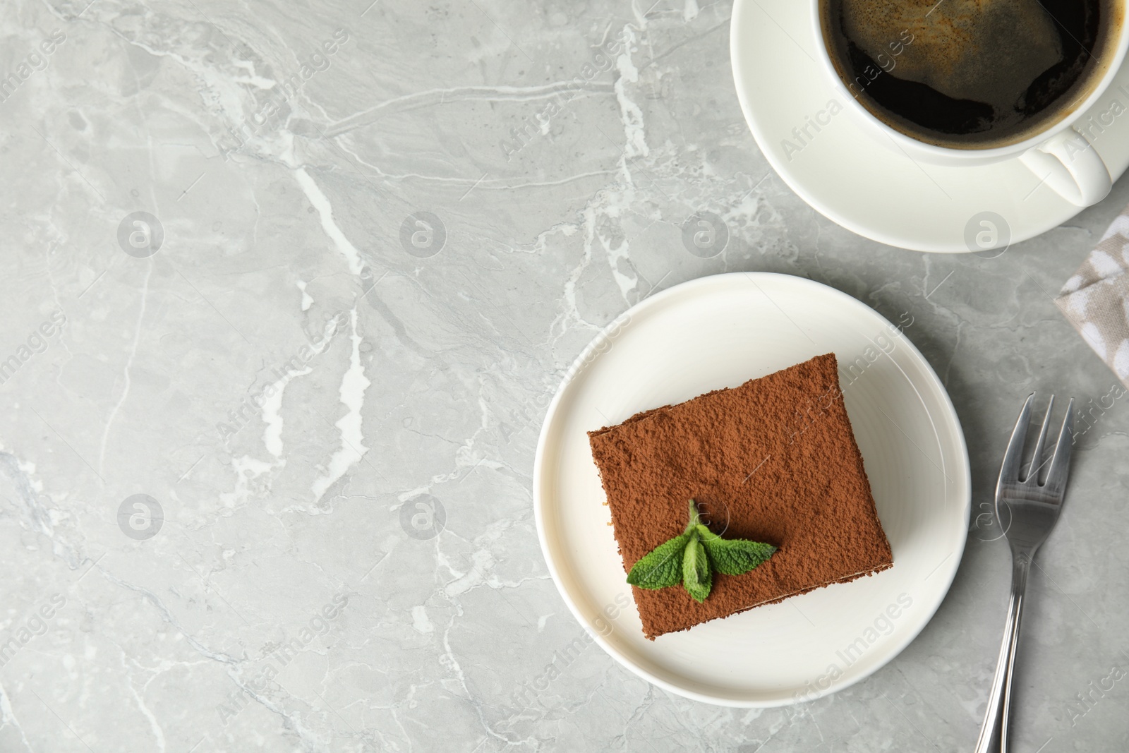 Photo of Flat lay composition with tiramisu cake and cup on table, space for text