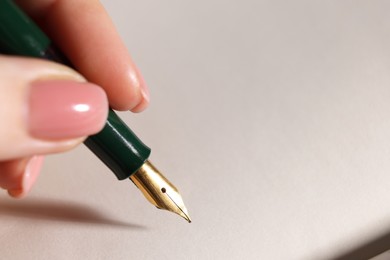 Photo of Woman writing with fountain pen, closeup. Space for text