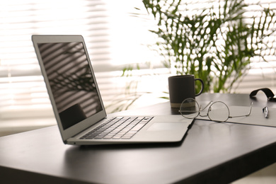 Photo of Modern laptop on office table. Stylish workplace