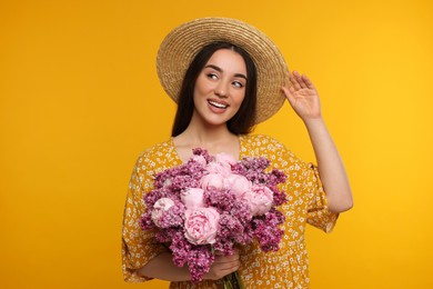 Photo of Beautiful woman with bouquet of spring flowers on yellow background