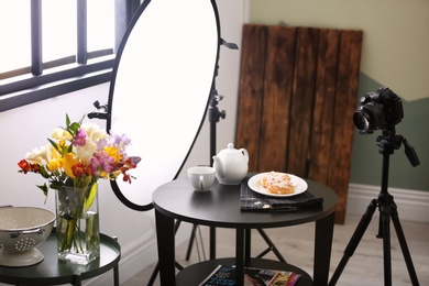 Professional camera on tripod and food composition in photo studio