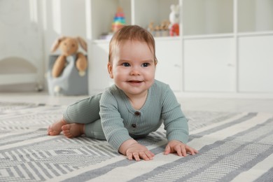 Photo of Cute baby crawling on floor at home