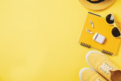 Flat lay composition with stylish shoes and accessories on yellow background. Space for text