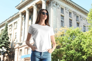 Photo of Young woman wearing white t-shirt on street