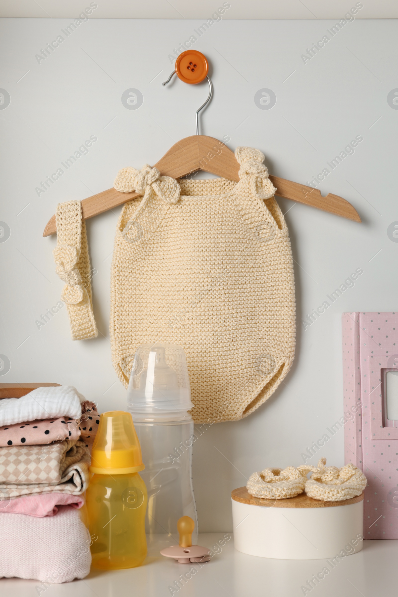 Photo of Baby clothes and accessories on white rack