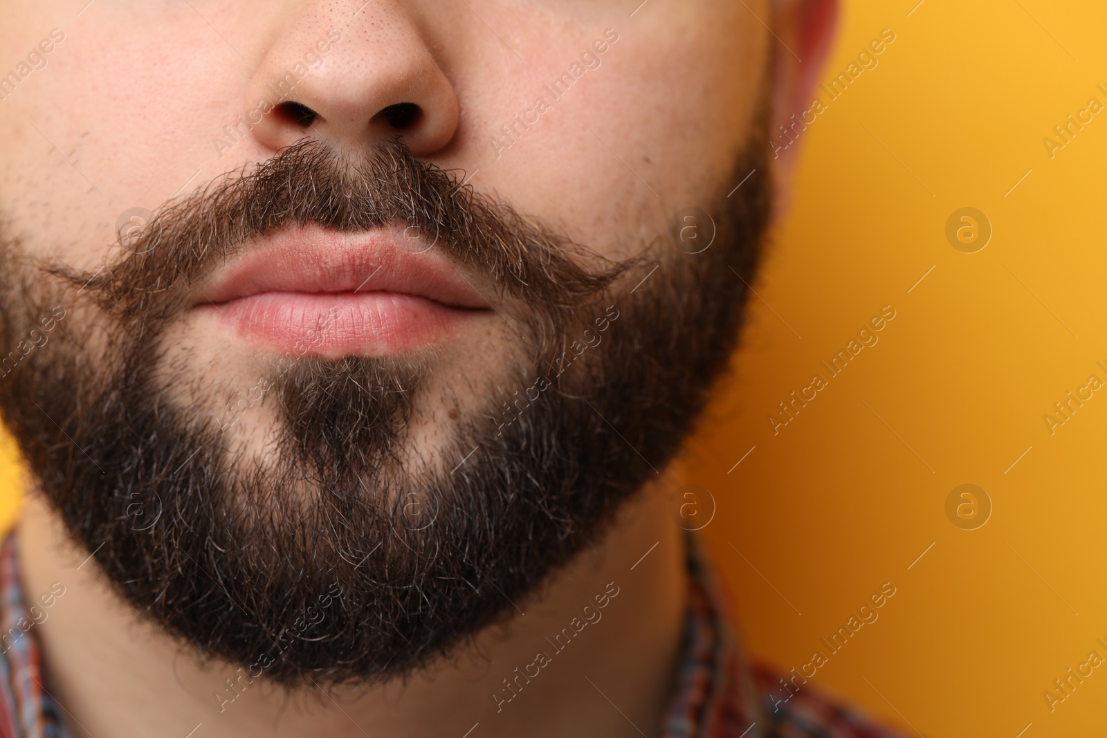 Photo of Handsome man with mustache on yellow background, closeup