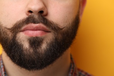 Photo of Handsome man with mustache on yellow background, closeup