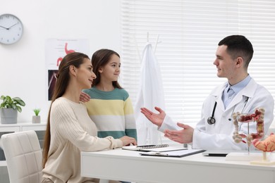Gastroenterologist consulting woman and her daughter in clinic