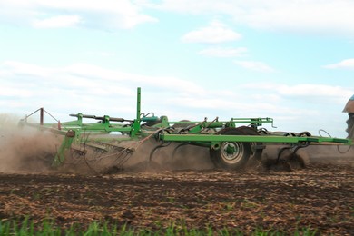 Planter cultivating field on spring day. Agricultural industry