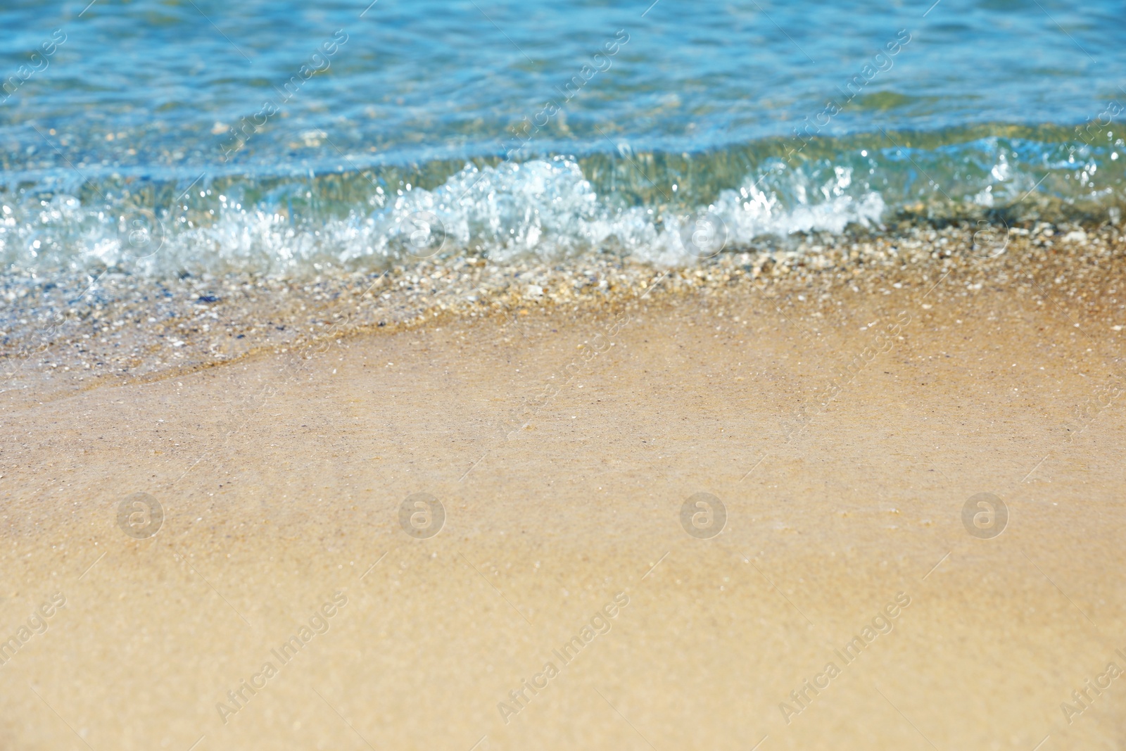 Photo of View of sea water and beach sand on sunny day