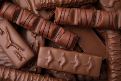 Photo of Many different tasty chocolate bars as background, top view