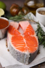 Photo of Fresh fish, rosemary and marinade on table, closeup