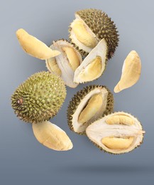 Image of Fresh ripe durians falling on grey background