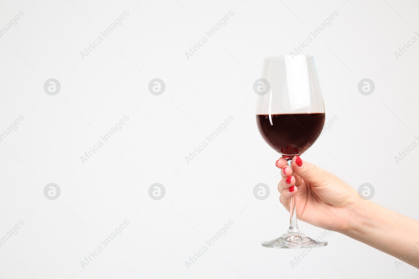 Photo of Woman holding glass of red wine on white background
