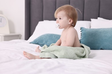 Photo of Cute little baby with towel after bathing on bed