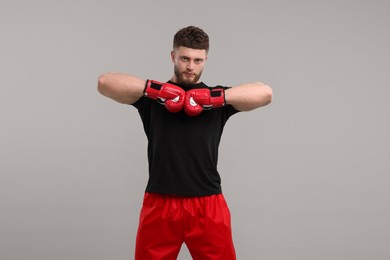 Photo of Man in boxing gloves on grey background