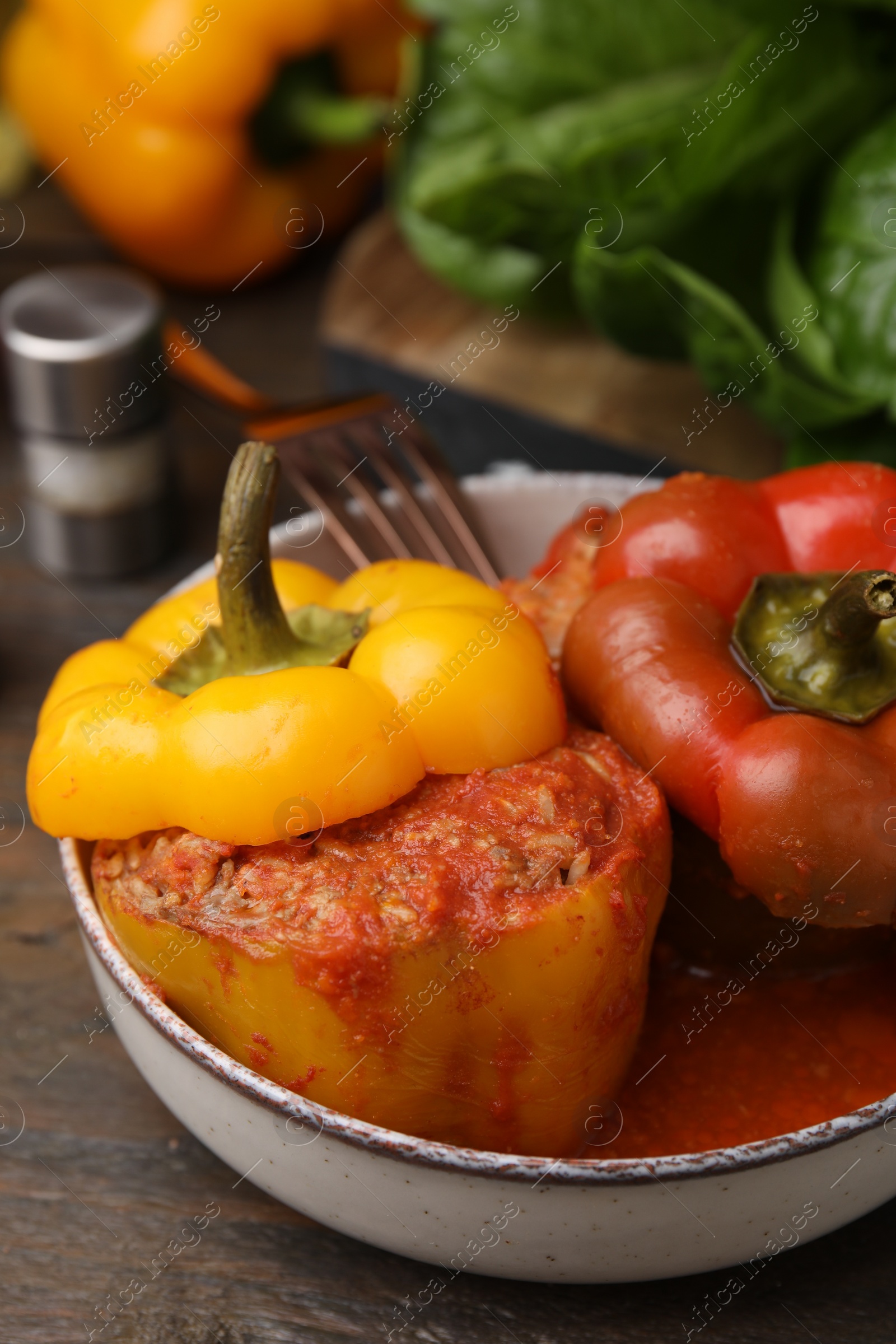 Photo of Delicious stuffed bell peppers served on wooden table