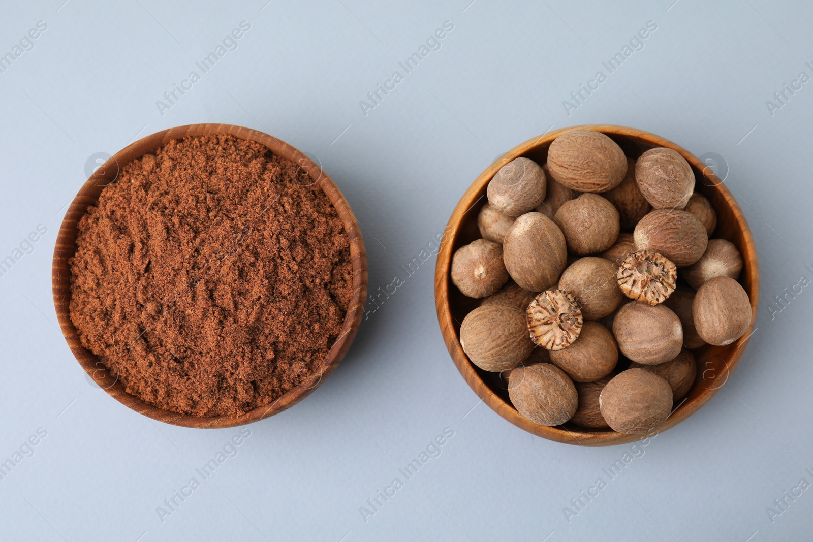 Photo of Nutmeg powder and seeds on white background, flat lay