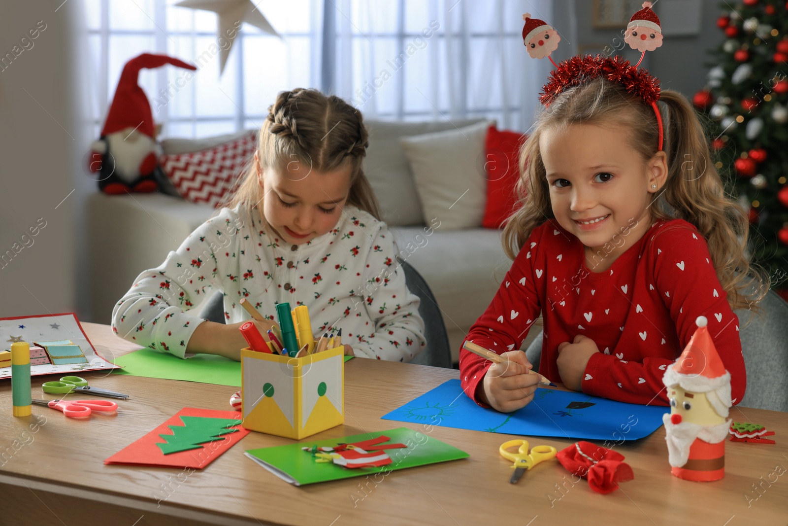 Photo of Cute little children making beautiful Christmas greeting cards at home