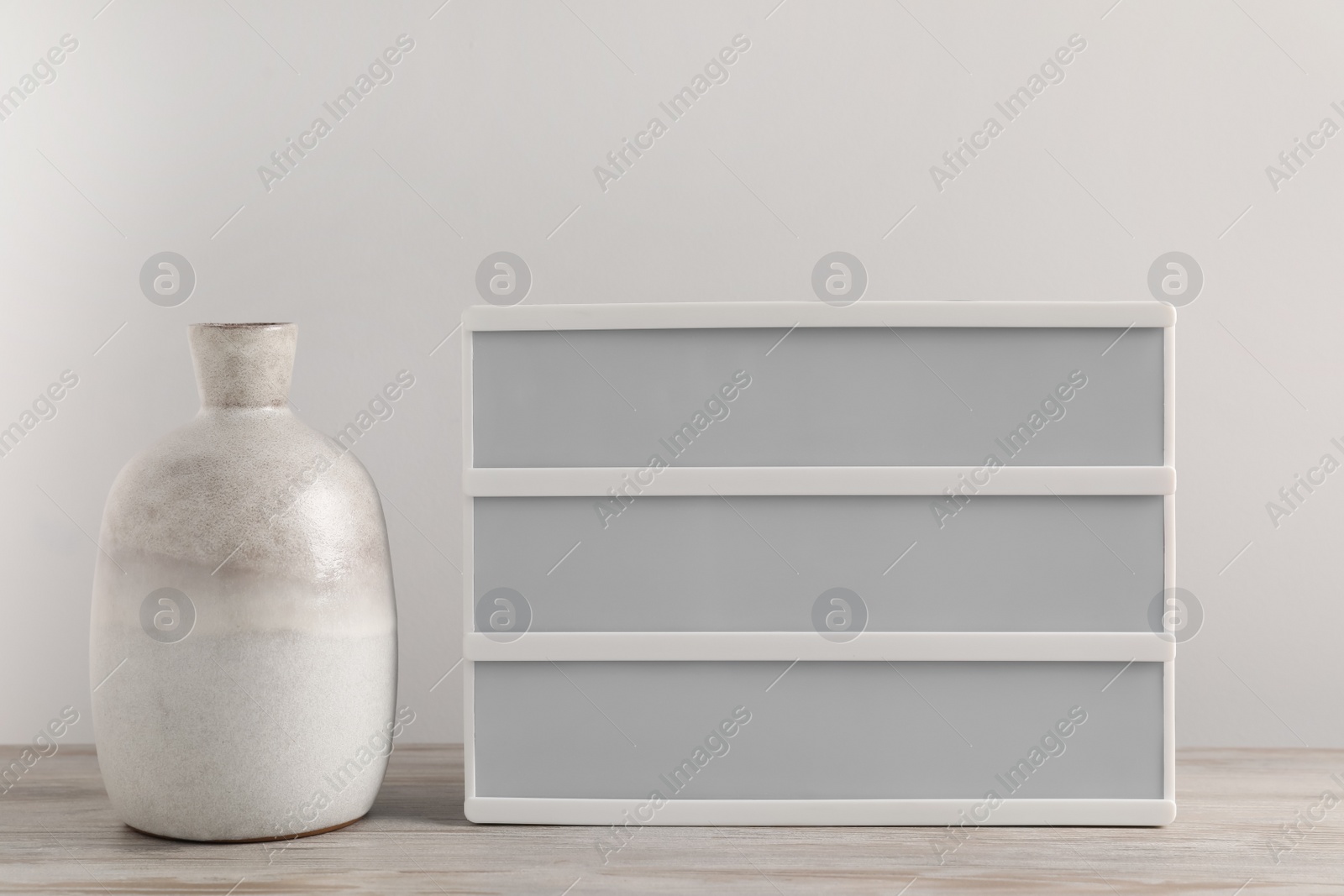 Photo of Blank letter board and vase on wooden table. Mockup for design