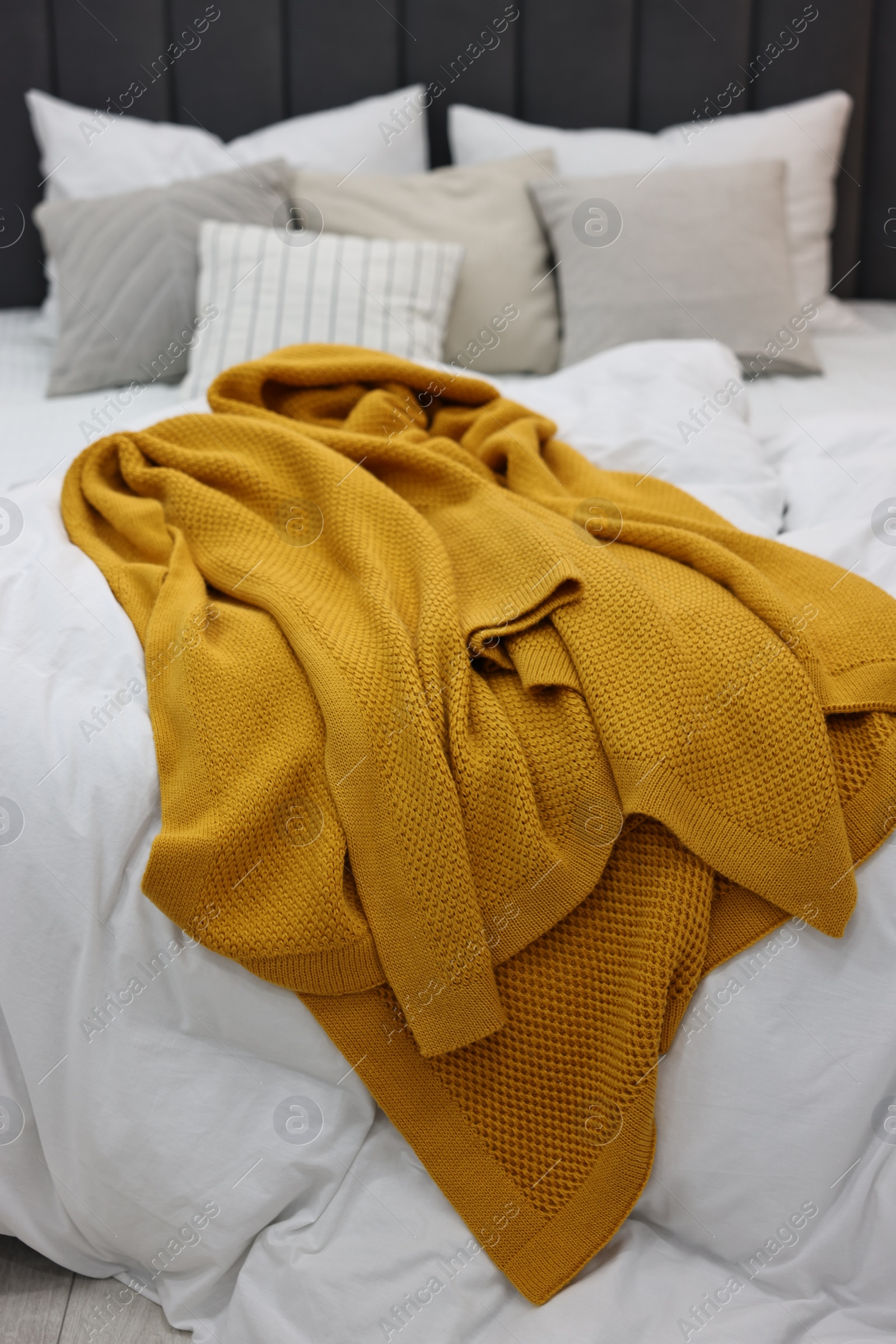 Photo of Soft plaid and pillows on bed in bedroom